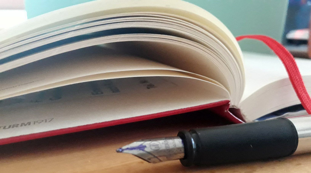 aufgeschlagenes Buch mit Füllhalter